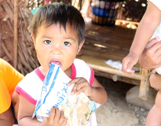 Child from Philippines eating a mobile pack meal