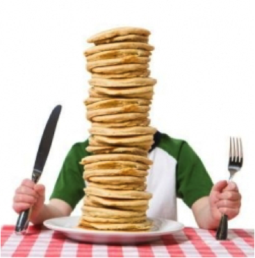 Boy with stack of pancakes taller than he is